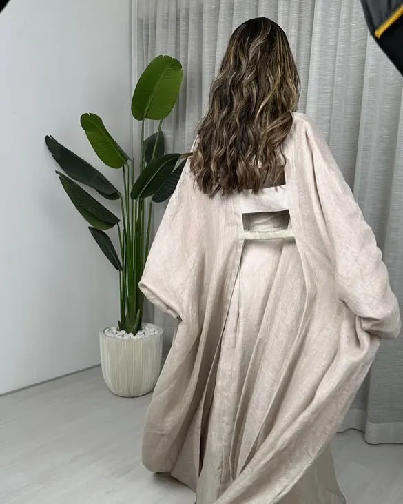 The linen robe from the back, moving as she walks