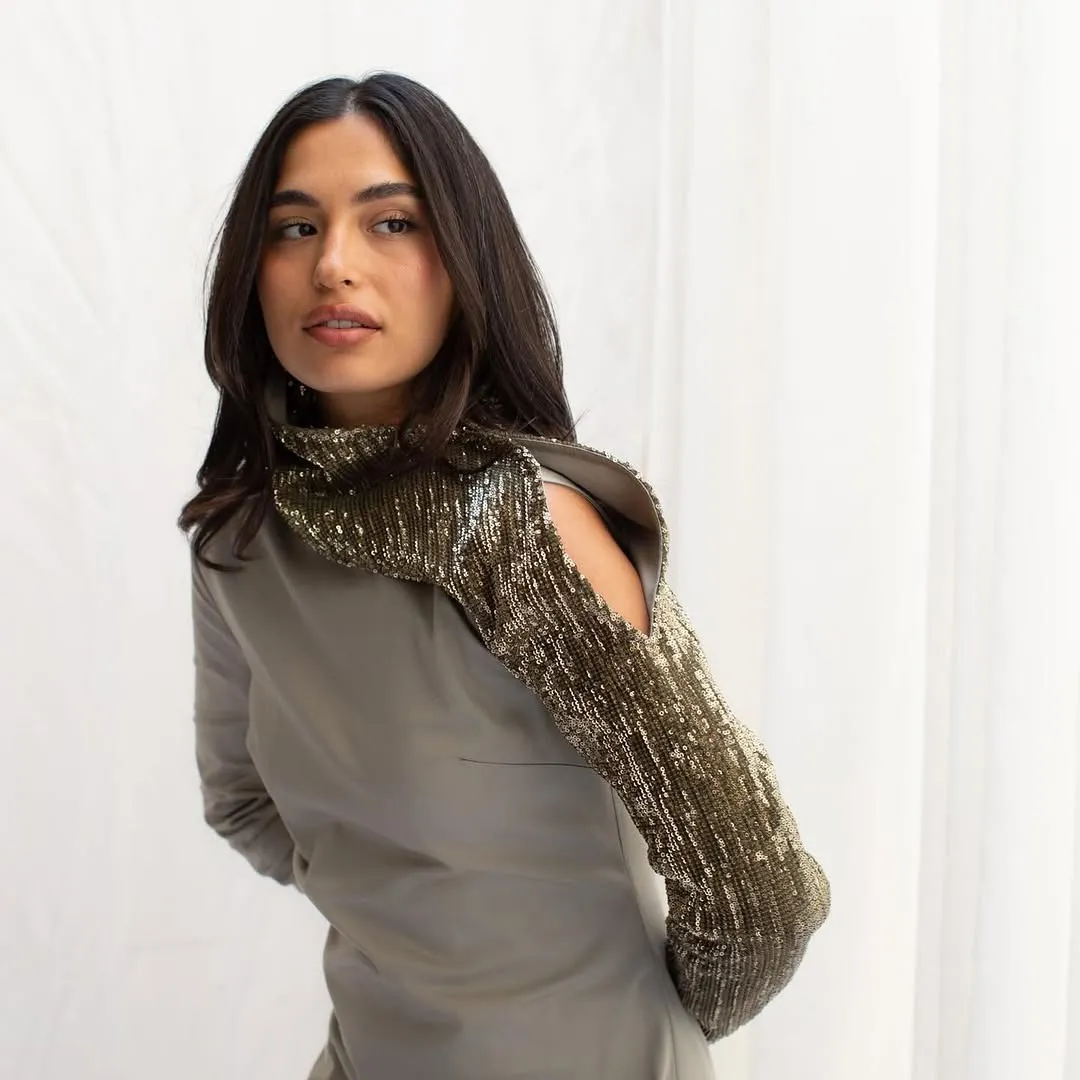 Close view of the taupe version with its sequin sleeve and open shoulder