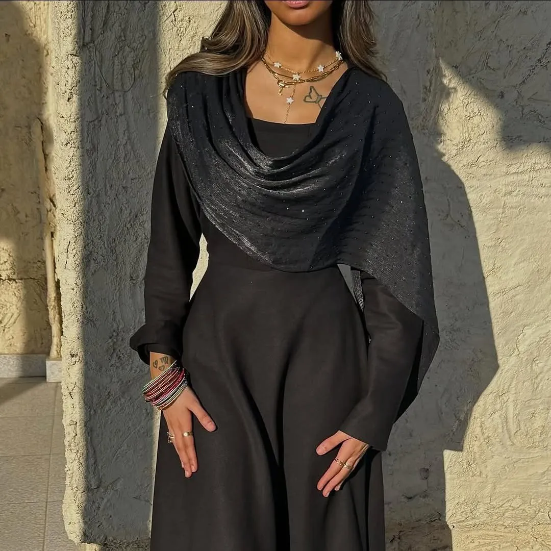 Black long dress with a shimmer shawl draped at the neckline, in golden light